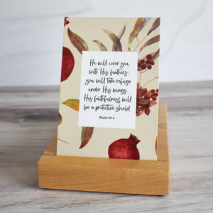 He will cover you with His feathers; you will take refuge under His wings. His faithfulness will be a protective shield. Psalm 91:4 Scripture Card displayed in premium wooden stand from Buhbay.com.