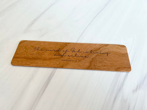 Wooden bookmark with Bible verse on it.